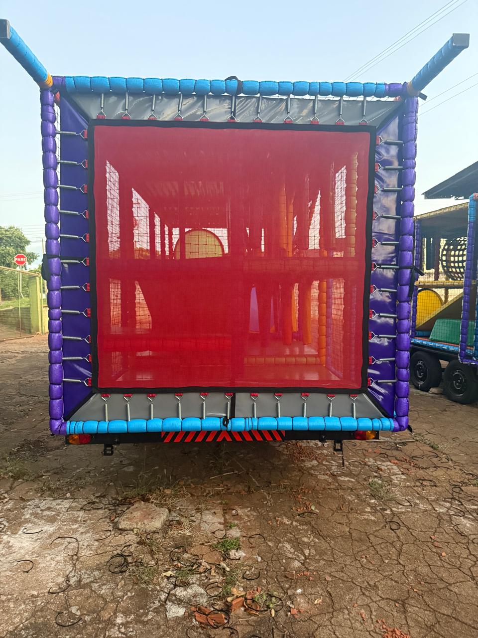 Traseira fechada da Carreta Playground Land Toys com rede de proteção vermelha e ganchos de segurança